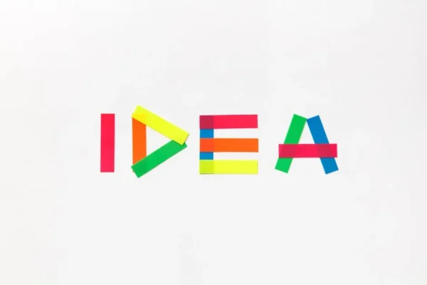 Vibrant colored tape spells 'IDEA' on a clean white background, symbolizing creativity.