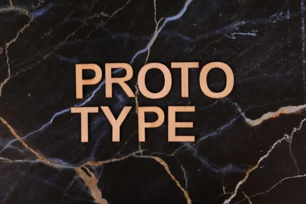 Wooden letters spelling 'PROTOTYPE' on a black marble surface, perfect for innovation themes.