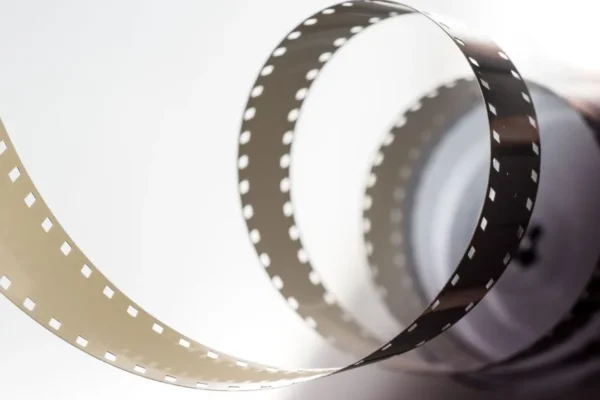 Close-up artistic view of a vintage filmstrip in a spiral design, highlighting its metallic texture.