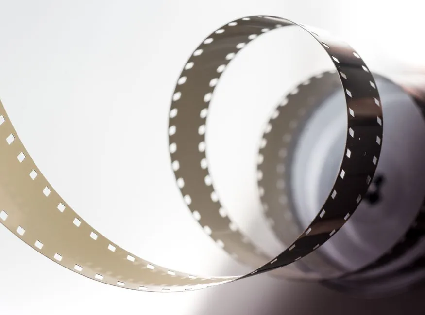 Close-up artistic view of a vintage filmstrip in a spiral design, highlighting its metallic texture.