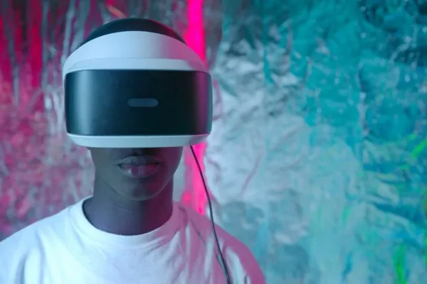 Teen enjoying virtual reality experience with vibrant neon lights.